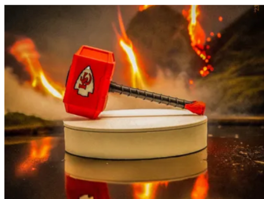 Red hammer with a white symbol on a reflective surface with flames in the background